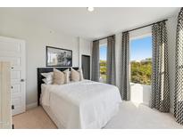Bright bedroom with white bedding, modern decor, and large windows with geometric patterned curtains at 915 Ball Field Aly # 305, Cary, NC 27511