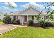 Charming single-story home featuring a well-manicured lawn and a cozy front porch with red shutters at 1113 Curtiss Dr, Garner, NC 27529