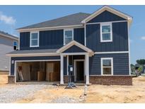 Two story home featuring a blue exterior, white trim and an attached garage awaiting finishing touches at 1233 Whitespire Way, Zebulon, NC 27597