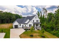 Stunning two-story home featuring white siding, dark grey accents, and a well-manicured front lawn at 164 E Spring Showers Trail Trl, Angier, NC 27501