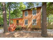 Two-story home surrounded by trees, featuring a front porch and ample natural light from numerous windows at 18 Frances St, Chapel Hill, NC 27517