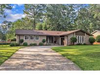 Charming brick home with well-manicured lawn and mature trees, inviting curb appeal and a welcoming atmosphere at 2003 Ryerson Dr, Garner, NC 27529