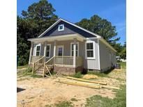 Charming exterior showcasing gray siding, a welcoming porch, and well-defined architectural details at 213 Maye St, Dunn, NC 28334