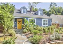 Charming home with a well-manicured front yard, yellow door, stone steps, and blue siding at 216 Northwood Cir, Durham, NC 27701