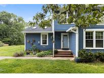 Charming blue two-story home featuring a landscaped front yard and a cozy entryway at 2214 Pathway Dr, Chapel Hill, NC 27516