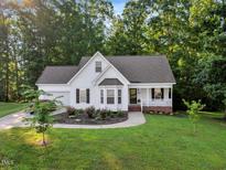 Charming one-story home featuring a manicured lawn, lovely landscaping, and a welcoming front porch at 240 Carrington Ave, Franklinton, NC 27525