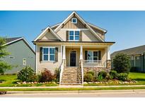 Charming home featuring a welcoming front porch with stone accents and manicured landscaping at 262 Salt Cedar Ln, Chapel Hill, NC 27516