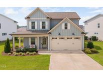 Charming two-story home with a well-manicured lawn, covered porch and a two car garage at 2806 High Plains Dr, Fuquay Varina, NC 27526