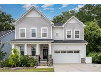 Charming two-story home features a welcoming front porch and attached two-car garage at 2914 Farmhouse Dr, Apex, NC 27502