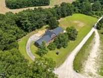 Aerial view showcases wooded property with a long driveway and a traditional home at 3129 Tarheel Clubhouse Road Rd, Raleigh, NC 27604