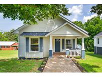 Charming home with a covered front porch and blue trim details set against a well-manicured lawn at 408 N Fourth/ 4Th St, Mebane, NC 27302