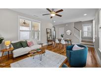 Inviting living room featuring hardwood floors, ceiling fan, comfortable seating, and a stylish coffee table at 444 Claremont Dr, Chapel Hill, NC 27516