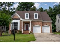 Charming two-story brick home with attached two-car garage and manicured front lawn at 5818 Myakka Ct, Raleigh, NC 27616