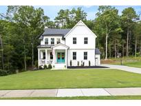 Charming two-story home with a bright blue front door, covered porch, and beautifully landscaped front yard at 720 The Parks Dr, Pittsboro, NC 27312