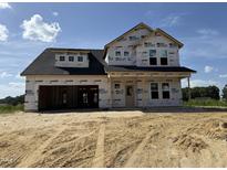 New home construction featuring a two-story design and a spacious front yard under a bright blue sky at 76 Tuskeegee Dr, Smithfield, NC 27577