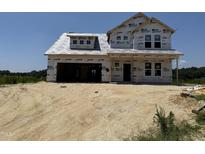 Exterior view of new two-story house construction with visible lumber and protective wrap, awaiting finishing touches at 76 Tuskeegee Dr, Smithfield, NC 27577
