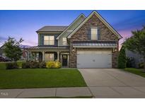 Charming two-story home boasting a stone facade, manicured lawn, and inviting front porch at 824 Stanly House St, Wake Forest, NC 27587