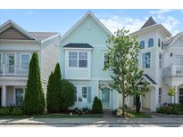 Charming two-story home with light blue siding, well-maintained landscaping, and mature trees on a sunny day at 979 Branch Line Ln, Apex, NC 27502