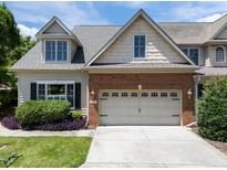 Inviting two-story home featuring a brick facade, manicured landscaping, and an attached two-car garage at 103 Aisling Ct, Cary, NC 27513