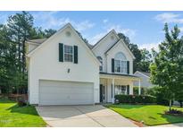 Charming two-story home with a well-manicured lawn, two-car garage, and traditional architectural details at 121 Trevor Ridge Dr, Holly Springs, NC 27540