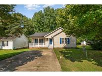 Charming single-story home with blue shutters, a cozy front porch, and a well-maintained lawn at 1261 Grovewood Dr, Clayton, NC 27520
