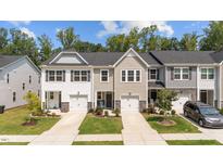 Charming townhomes with single-car garages, manicured lawns, and stone accents create an inviting curb appeal at 156 Velvet Ridge Way, Garner, NC 27529