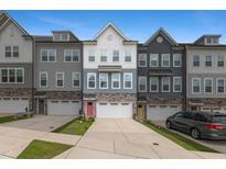 Charming new construction townhomes with stone accents, private garages, and colorful front doors create a welcoming neighborhood feel at 2006 Leo Dr, Apex, NC 27502