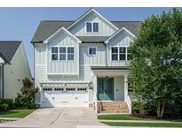 Charming home featuring light blue siding, white trim, an attached garage, and a welcoming front porch at 2013 Woodbluff Dr, Wendell, NC 27591