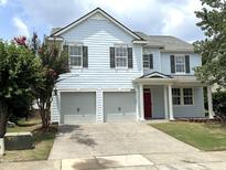 Charming two-story home with light-blue siding, gray garage doors, and well-maintained landscaping at 205 Bog Hill Ln, Cary, NC 27519