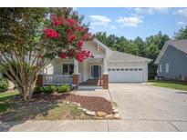 Inviting single-story home with a well-manicured lawn and a charming covered front porch at 209 Homegate Cir, Apex, NC 27502