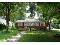 Charming brick home with a well-manicured lawn and mature trees at 2100 Breeze Rd, Raleigh, NC 27608