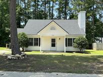 Charming one-story home with a classic white exterior and well-manicured lawn and a gray roof at 2116 Tanglewood Rd, Rocky Mount, NC 27804