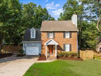 Charming brick home featuring a well-maintained lawn and inviting orange front door at 2205 Bufflehead Rd, Raleigh, NC 27616