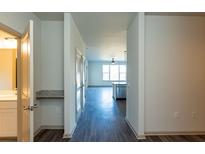 Bright hallway featuring wood floors leads to an open-concept kitchen and living area at 2321 Gathering Sq Ct, Fuquay Varina, NC 27526