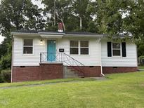 Charming single-story home with brick foundation, a blue door, and a well-maintained lawn at 2331 Kennington Rd, Raleigh, NC 27610