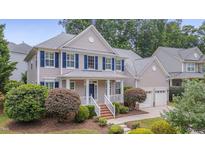 Charming two-story home with blue shutters, manicured lawn, and attached two-car garage at 2420 Rogerson St, Raleigh, NC 27614