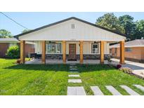 Charming home featuring a covered porch with wooden beams, stone accents, and a well-manicured lawn at 2803 Atlantic St, Durham, NC 27707
