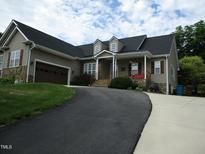 Charming home featuring stone accents, dormer windows, an attached garage, and a cozy front porch at 3008 River Hill Ln, Burlington, NC 27217