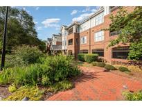 View of the condominiums with manicured landscaping and brick walkway at 3701 Baron Cooper Pass # 303, Raleigh, NC 27612