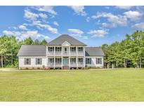 Stunning two-story home with a double balcony and a bright blue front door at 407 Kadir Womble Dr, New Hill, NC 27562