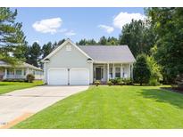 Charming single-story home with a well-manicured lawn, two-car garage, and inviting front porch at 4111 Branchwood Dr, Durham, NC 27705