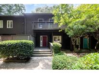 Inviting two-story townhome with a red front door, balcony, and lush greenery at 4403 Sunburst Ct, Raleigh, NC 27613