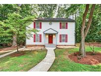 Charming two-story home featuring red shutters, a bright red door, and a landscaped front yard with a concrete walkway at 508 Bolin Creek Dr, Carrboro, NC 27510