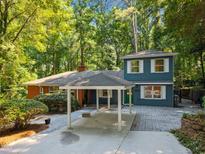Charming two-story home with a carport, brick accents, and lush landscaping at 5257 Vann St, Raleigh, NC 27606