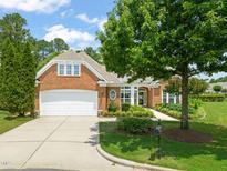 Charming brick home featuring a two-car garage, well-maintained landscaping, and a cozy, inviting entrance at 606 Corrigan Way, Cary, NC 27519
