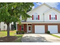 Charming townhome with a brick facade, a two-car garage, and a well-maintained front yard at 617 Woodson Dr, Clayton, NC 27527
