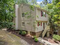Inviting two-story home featuring red shutters and a chimney, nestled among lush greenery at 6422 English Oaks Dr, Raleigh, NC 27615