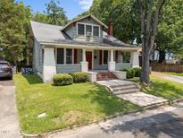 Charming craftsman home featuring a covered front porch with red shutters and brick-lined steps at 708 Parker St, Durham, NC 27701