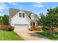 Charming two-story home featuring an attached garage, well-maintained lawn, and inviting front porch at 741 Rockville Rd, Wake Forest, NC 27587
