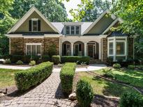 Charming stone and shake home with manicured landscaping and inviting front porch at 8504 Carlton Oaks Dr, Wake Forest, NC 27587